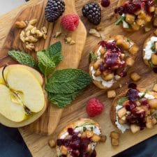 Apple Bruschetta on a wooden cutting board with apple slices