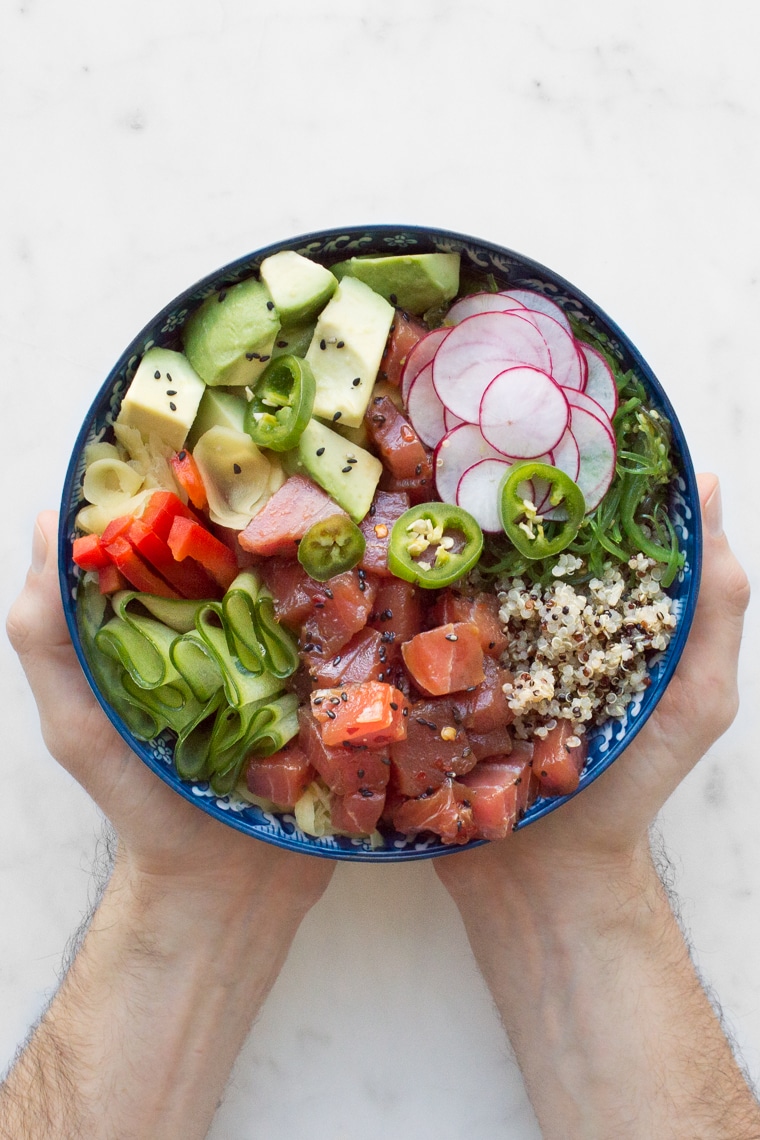 Above view of hands holding a Hawaiian Poke Bowl