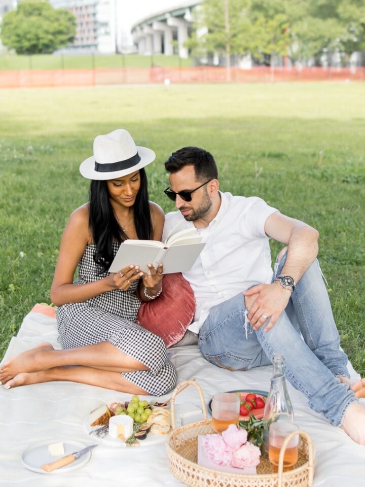 Couple reading a book together while having a picnic in the city