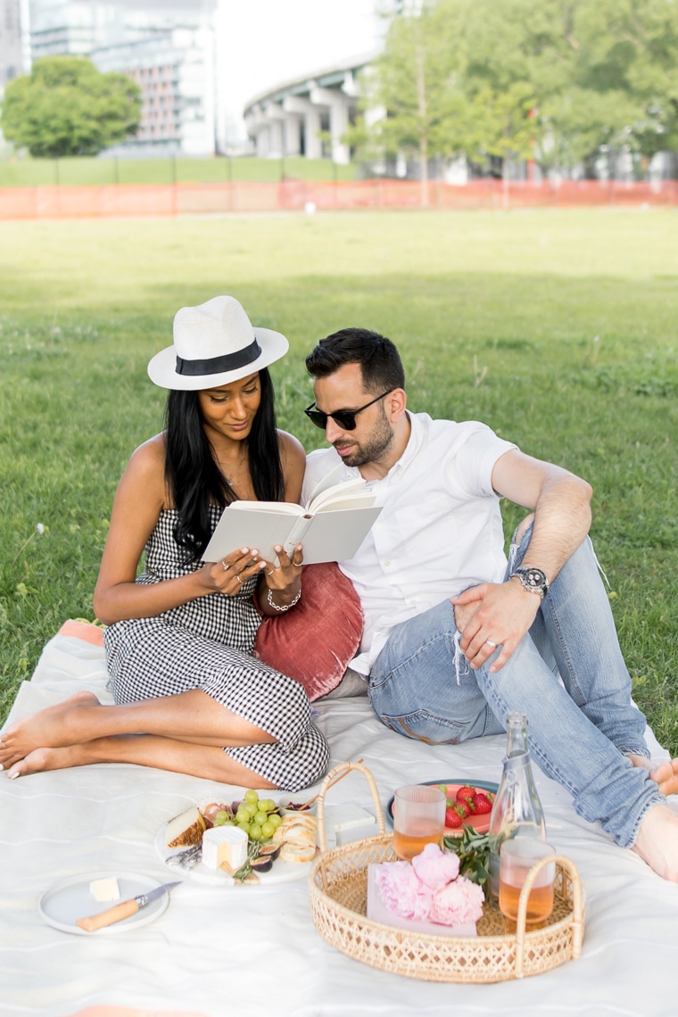 Couple reading a book together while having a picnic in the city