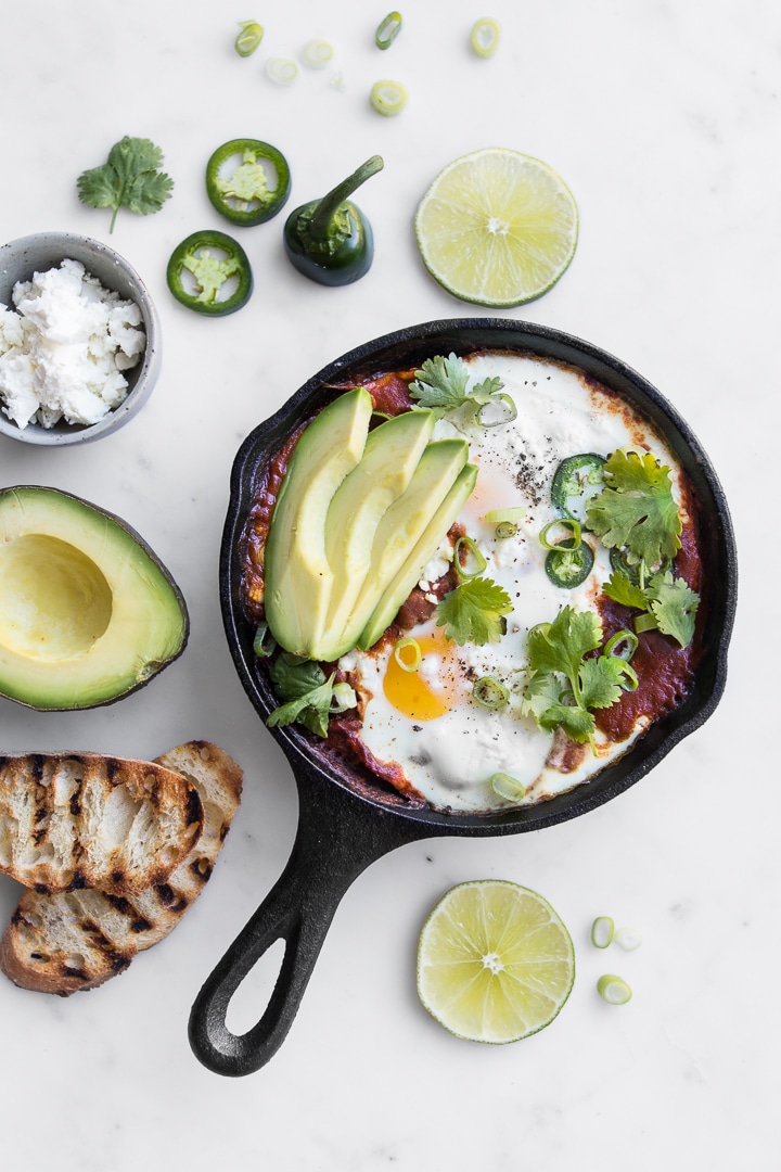 Small Cast Iron Skillet with Shakshouka topped with Sliced Avocado