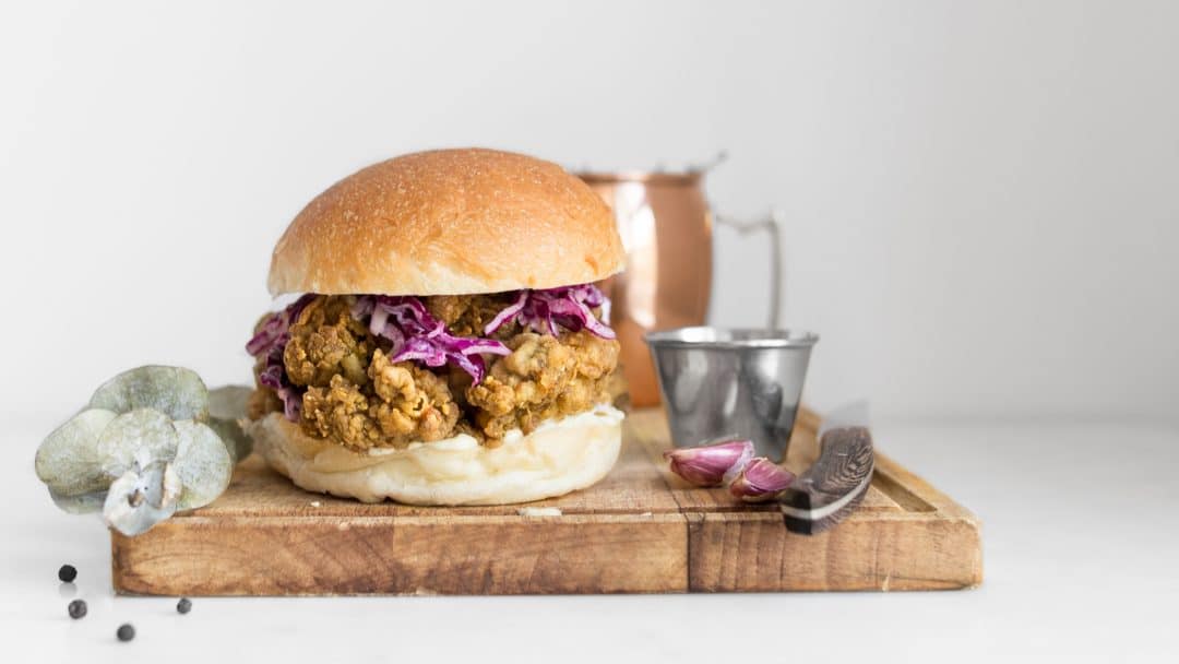 Curry Fried Chicken Sandwich with Purple Coleslaw on a Wooden Board