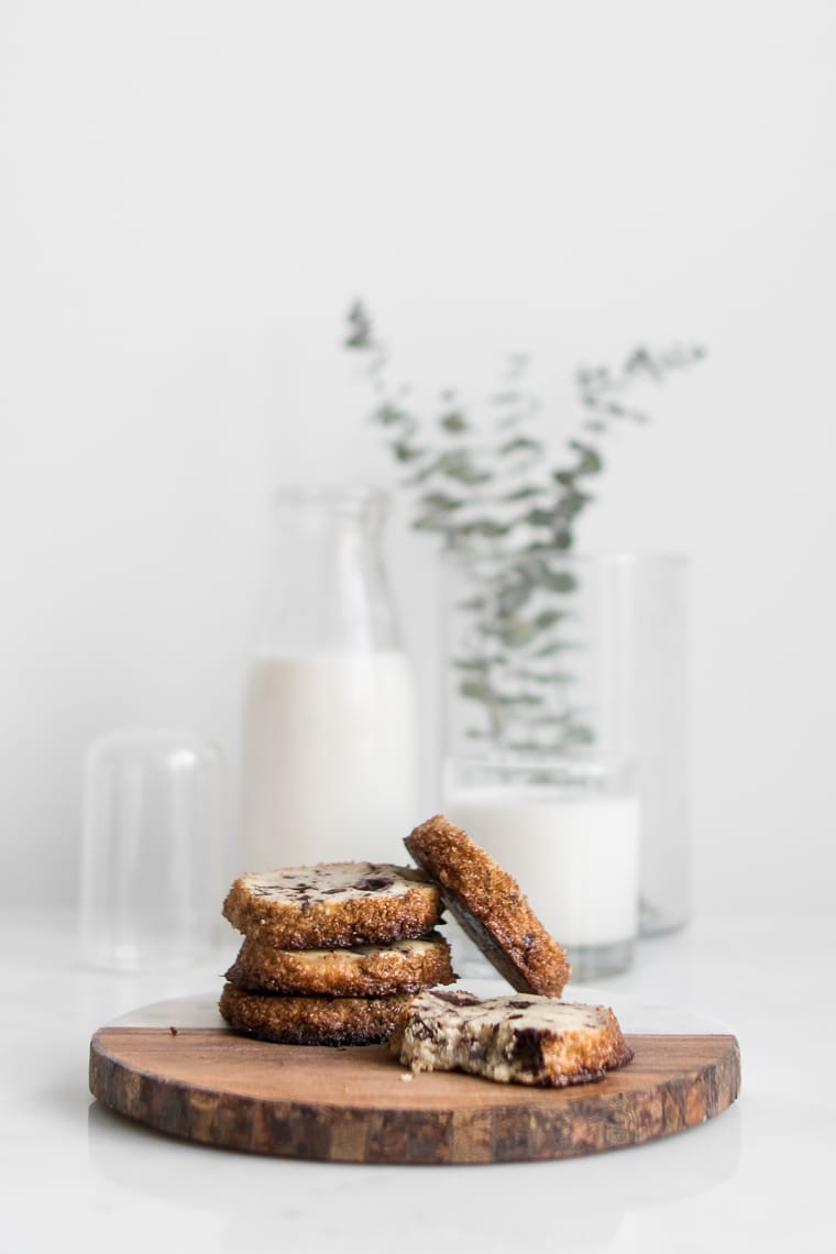 Dining In Cookbook Review - Chocolate Chunk Shortbread Cookies on a wood board with milk in the background