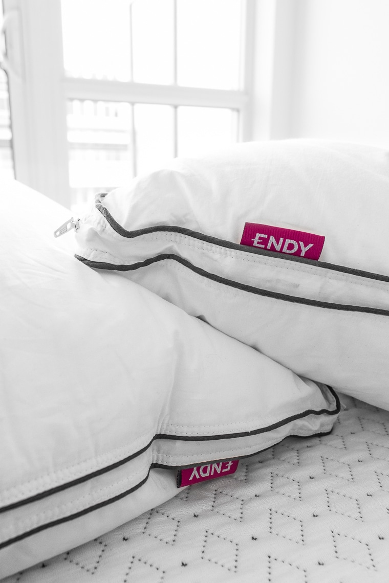 Close up image of Endy pillows with grey stripe and pink Endy logo