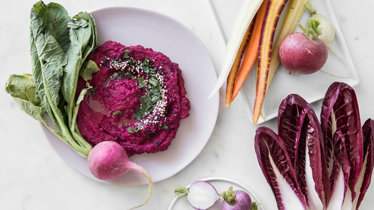 Close up of Roasted Cauliflower and Beet Hummus on a pink plate