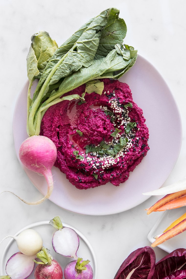 Close up of Roasted Cauliflower and Beet Hummus on a Pink Plate with a Fresh Raddish