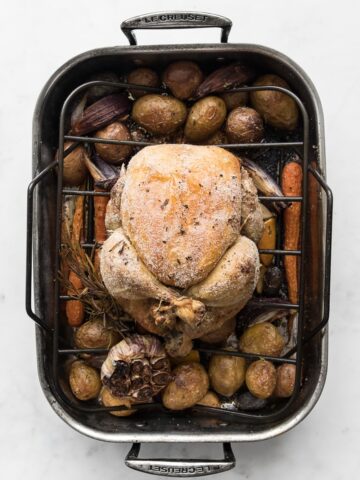 Roast chicken in a roasting pan with vegetables