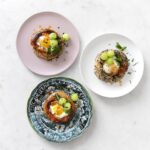 Overhead of three eggs in a bagel hole on three separate plate