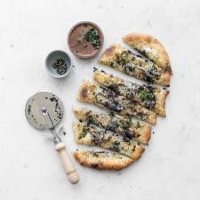 Cacio e Pepe Pizza with Spring Ramps next to pizza cutter