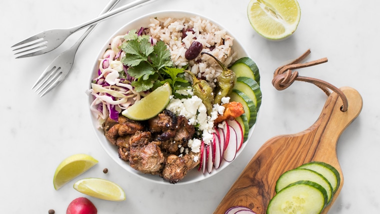 BBQ Jerk Chicken Bowl with Rice and Peas styled with lime, cucumbers and radishes