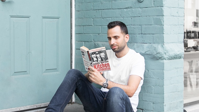 Reading on of the top 5 books by chefs leaning against a brick wall