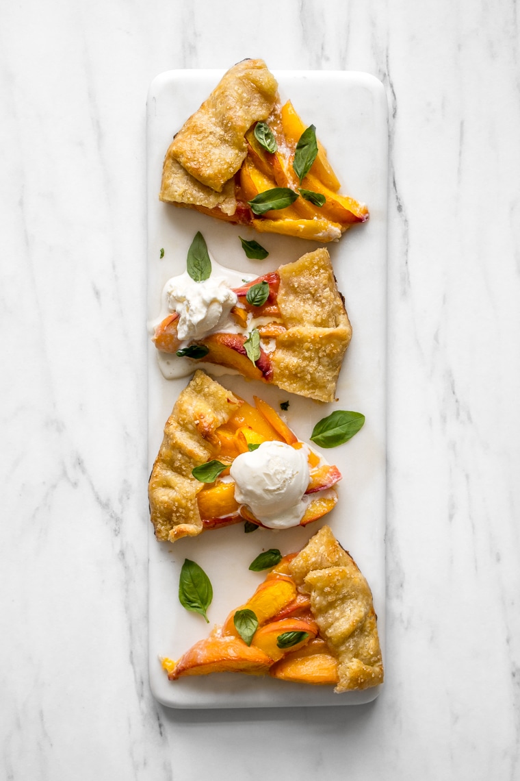 4 slices of peach galette on a marble board