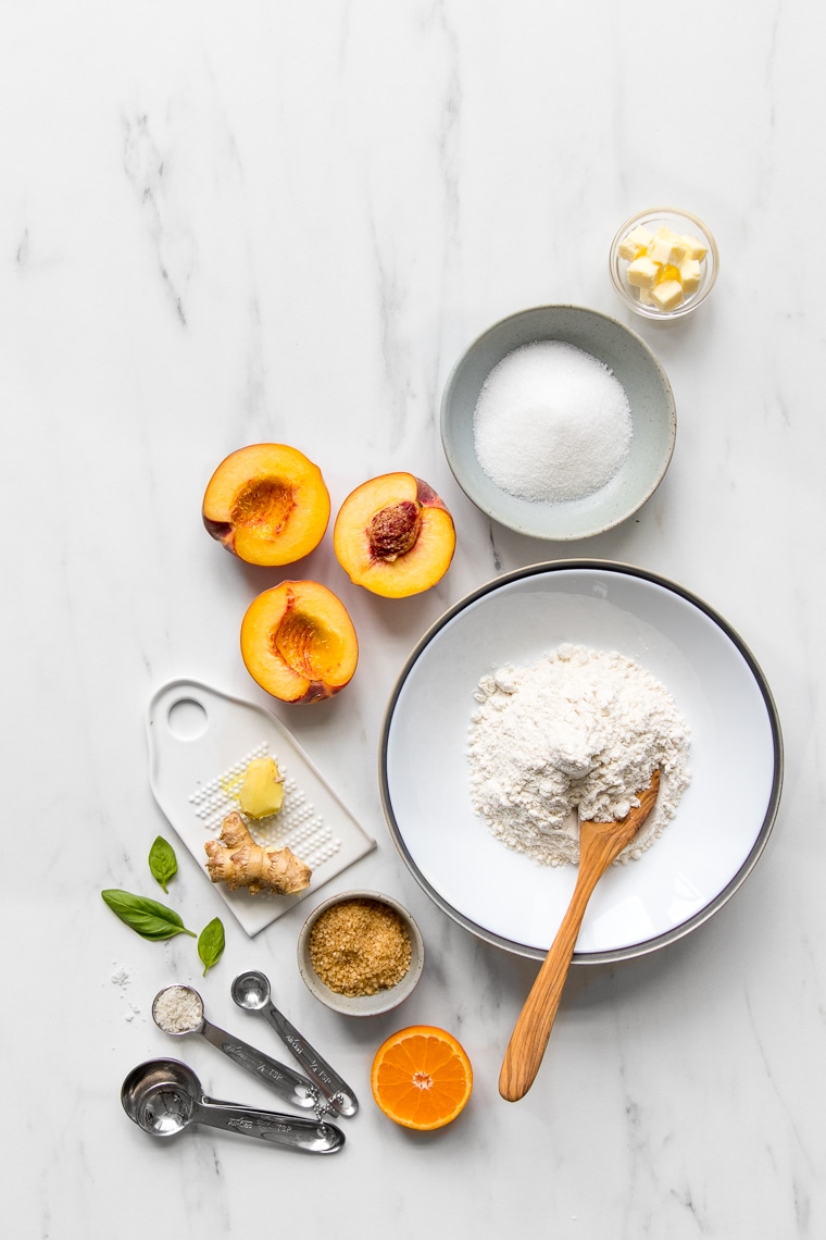 Ingredients for peach galette laid out on marble table