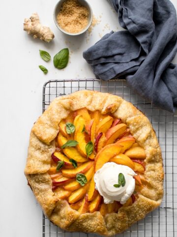 Peach galette cooling on a wire rack with a scoop of ice cream