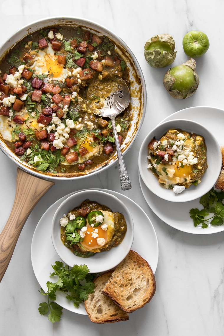 Green Shakshuka Recipe with Bacon and Tomatillo Sauce - Served as an early meal, brunch or a weeknight dinner, it’s a one-skillet dish that’s filled with bright and spicy notes and is as effortless as it is delicious, and our take on it is the perfect blend of a Middle-Eastern and Mexican flair. #brunch #breakfast #comfortfood #foodphotography #foodstyling