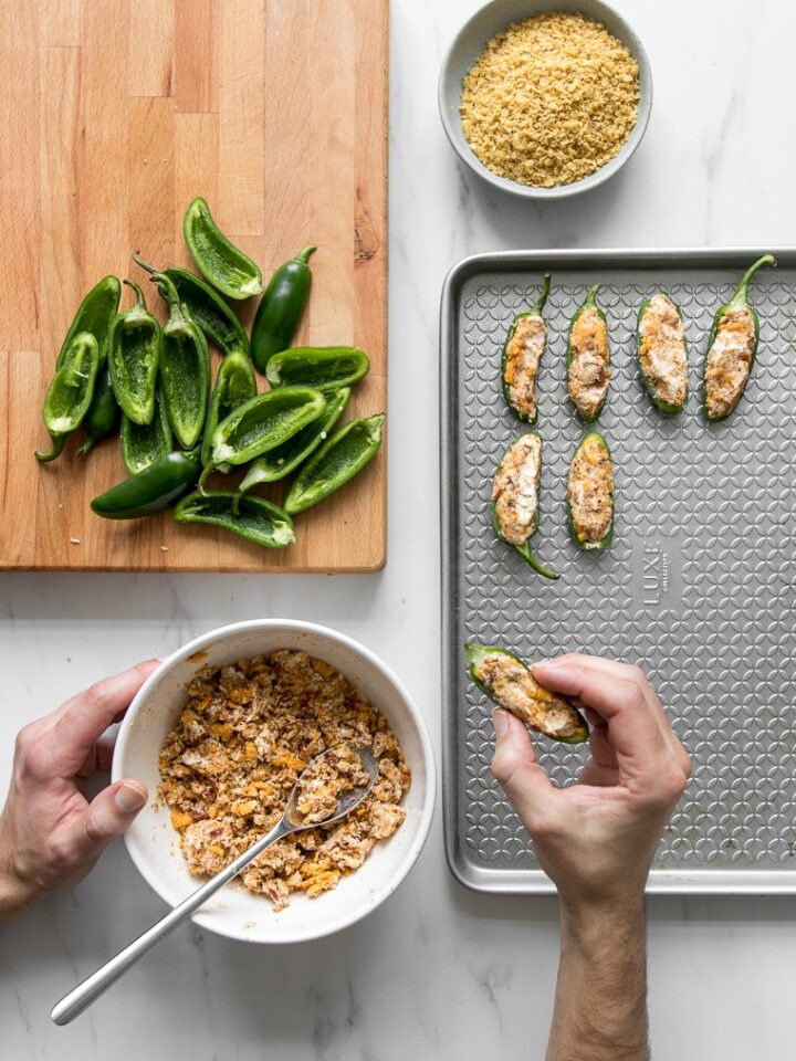 Filling the jalapeno peppers with the cheese mixture