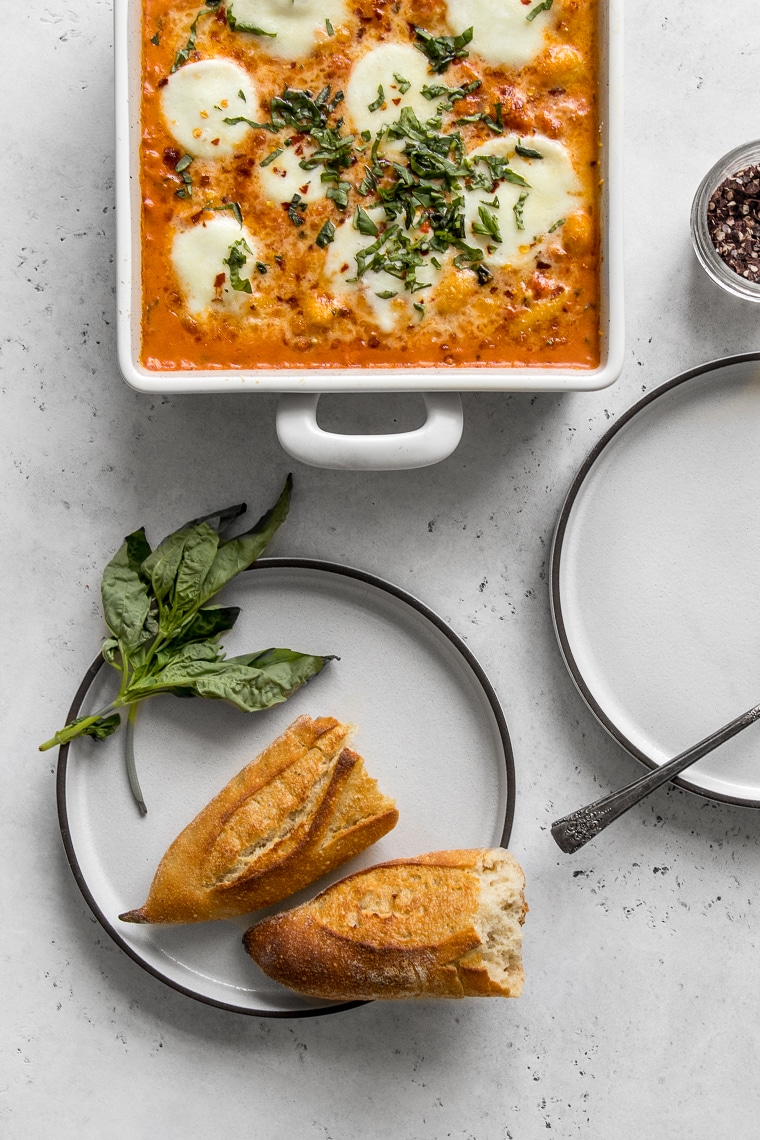 Baking dish with Baked Gnocchi with Vodka sauce and two empty plates