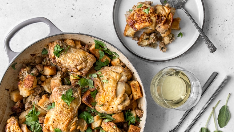 One Pot Chicken and Stuffing in a casserole and plated on a dish, with a glass of white wine
