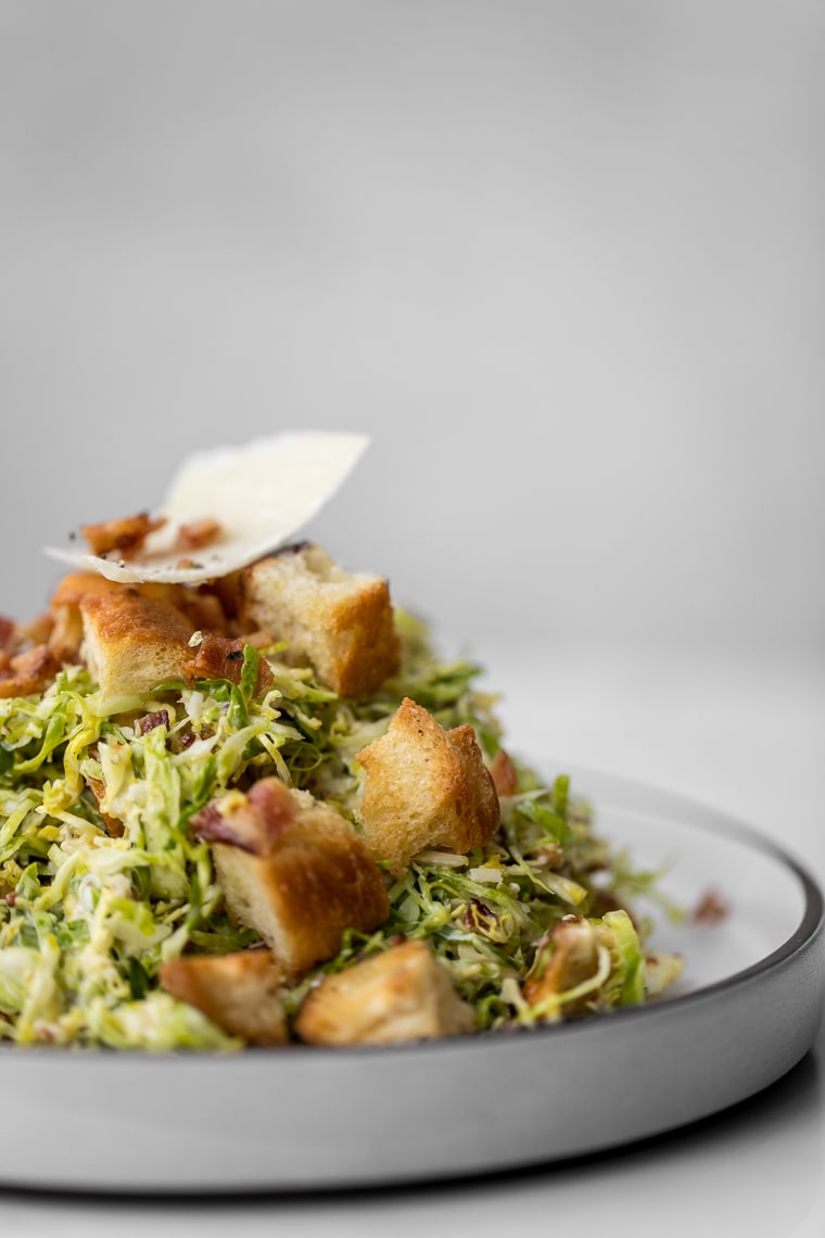 Side shot of Brussels Sprout Caesar Salad on a Plate