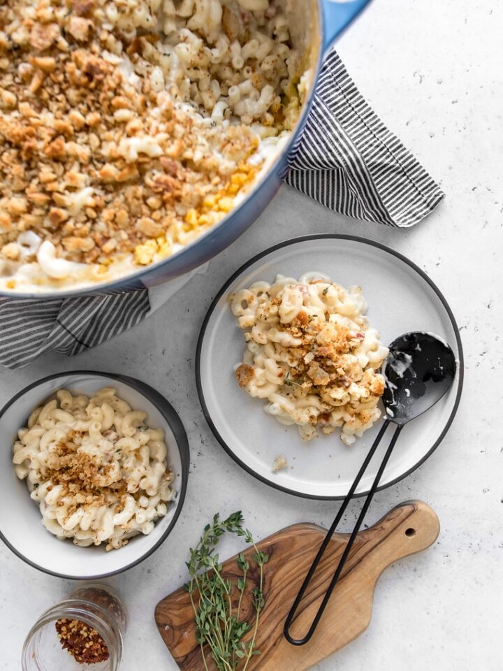 Blue Pot with Macaroni and cheese with two plates of mac and cheese and a black spoon