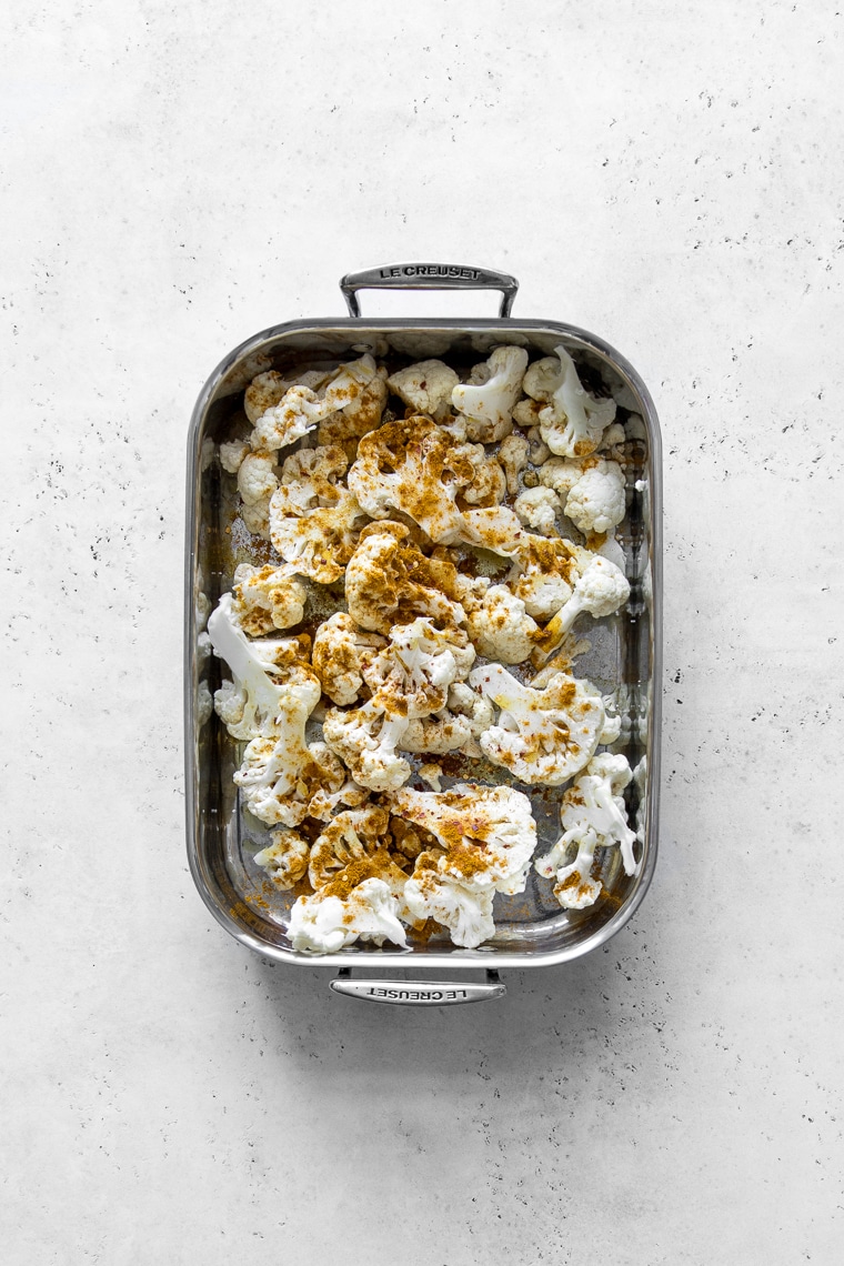 Cauliflower in a roasting pan with curry powder