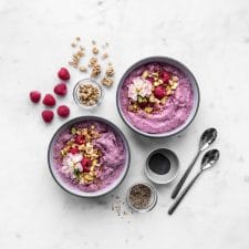 Two Smoothie Bowls with Granola, Raspberries and Seeds