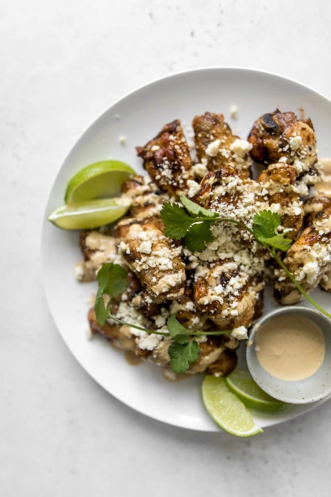 Plate of Chicken Wings with cotija cheese, spicy sauce and cilantro