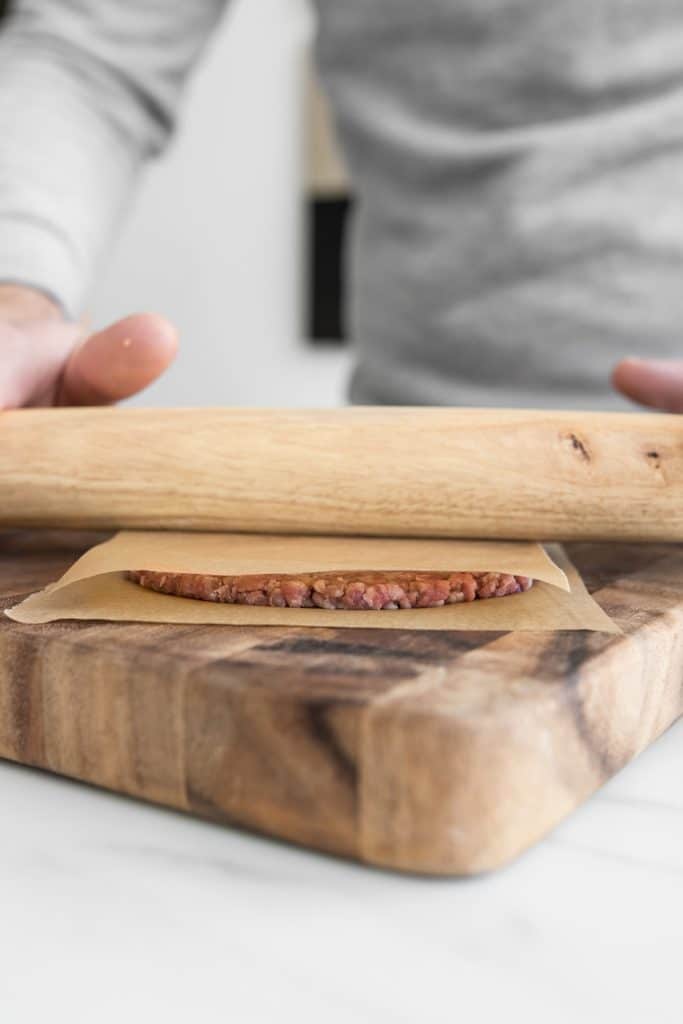 Rolling ground beef into patties with a rolling pin
