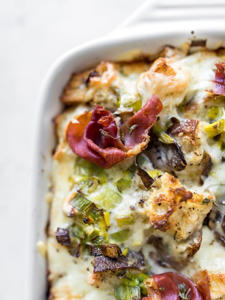 Close up of breakfast casserole with mushrooms and leeks with prosciutto on top