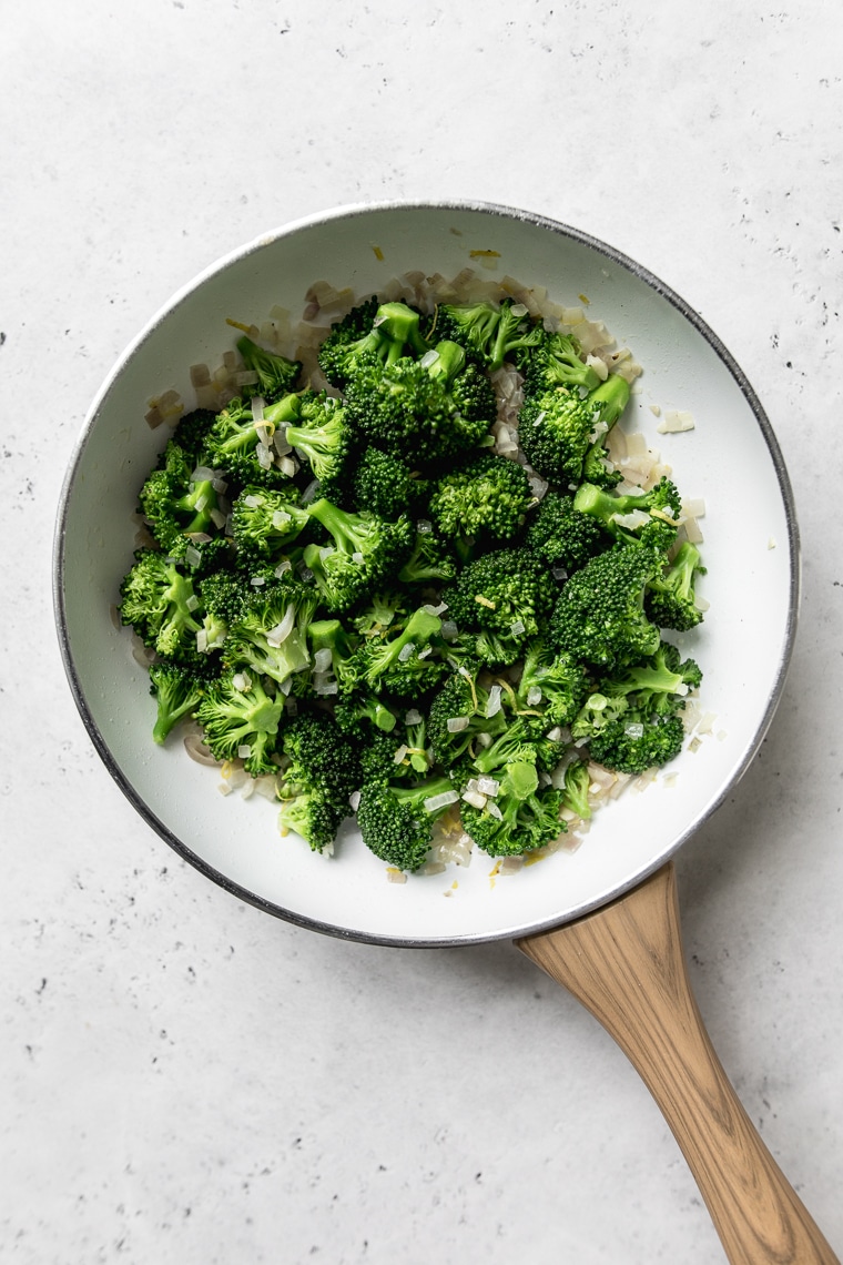 Sautéed broccoli and a white frying pan