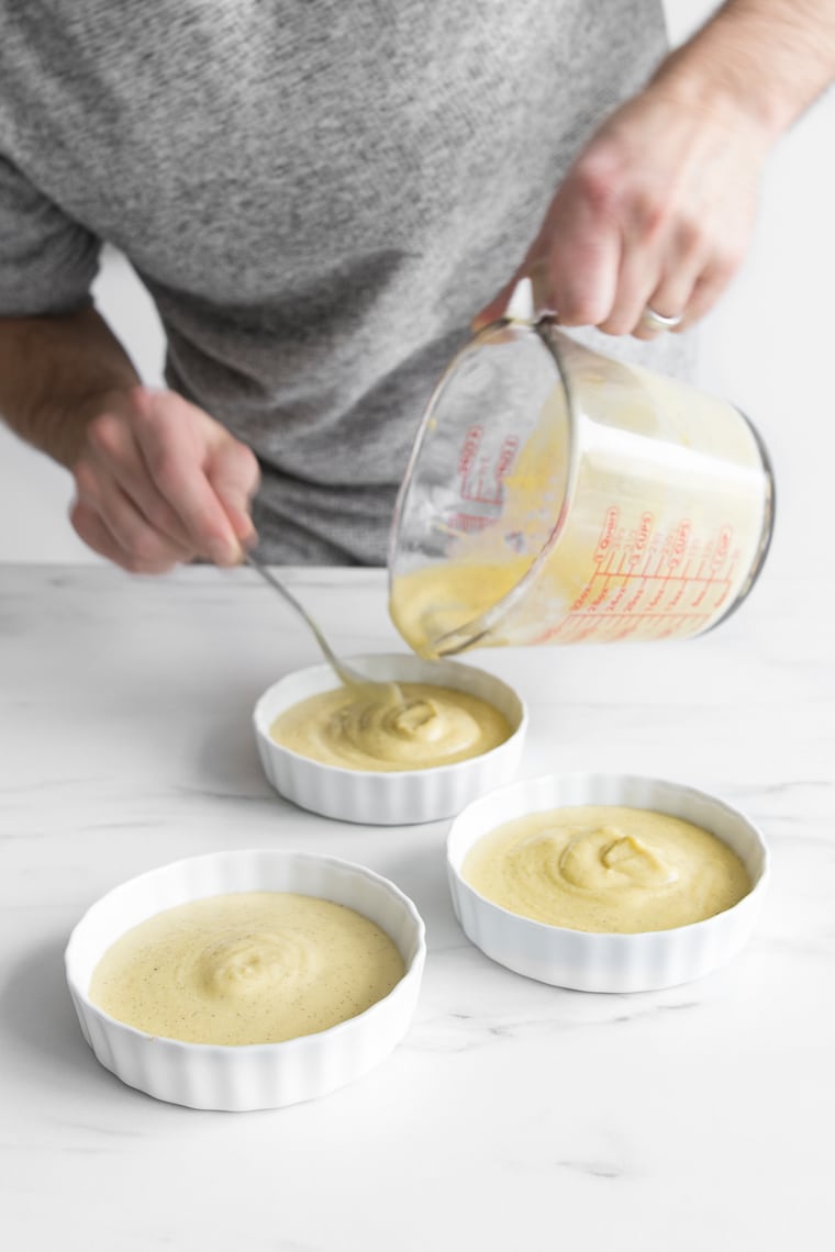 Pouring dairy-free creme brulee mixture into ramekins