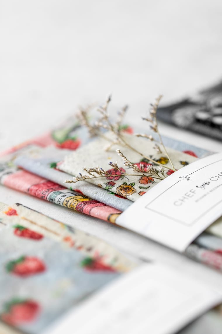 Close-up of Packaged Reusable Beeswax Wraps with Sprig of Flowers