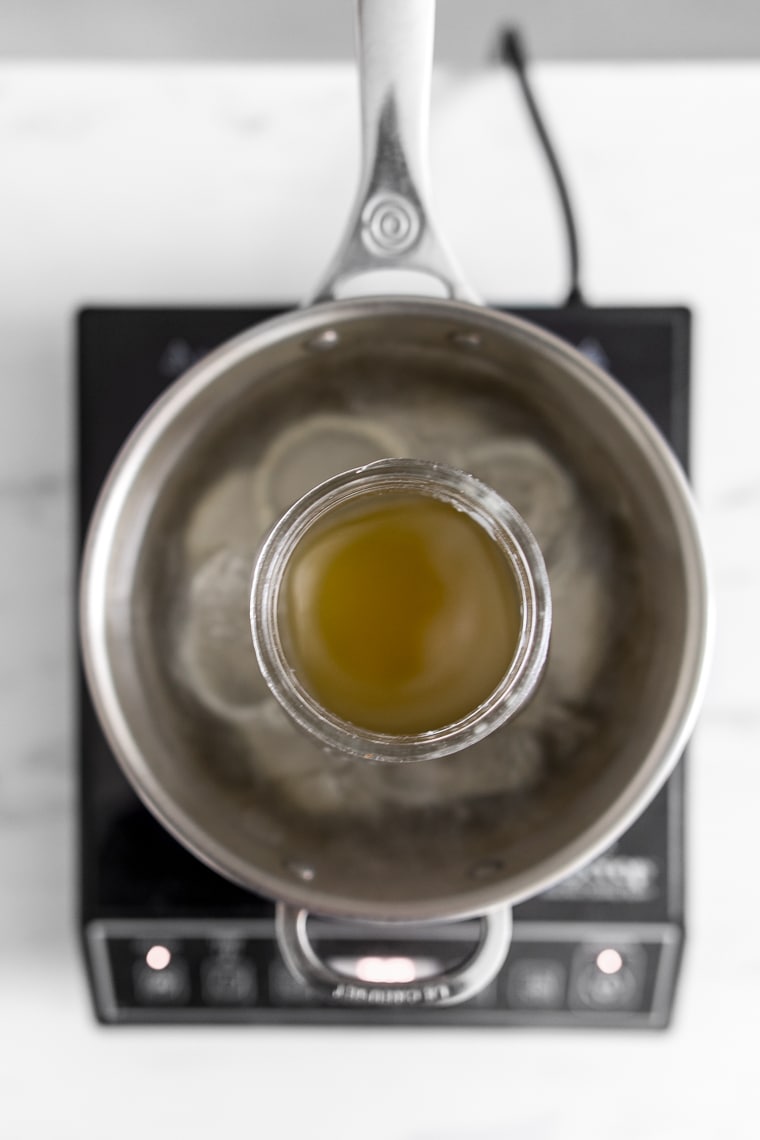 Photo from above of a jar in a pot of water with melted beeswax inside