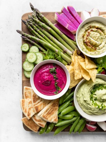 Close Up of White Bean and Beet Hummus with Vegetables and Pita Chips