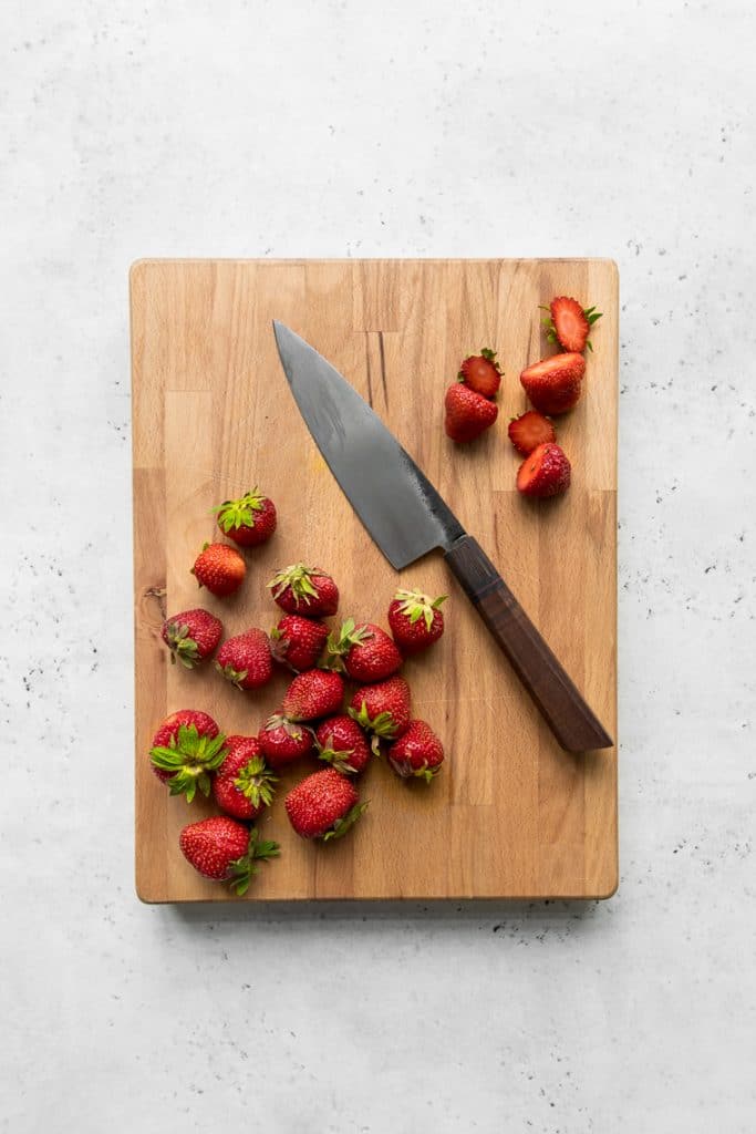 Strawberries and a knife on a cutting board