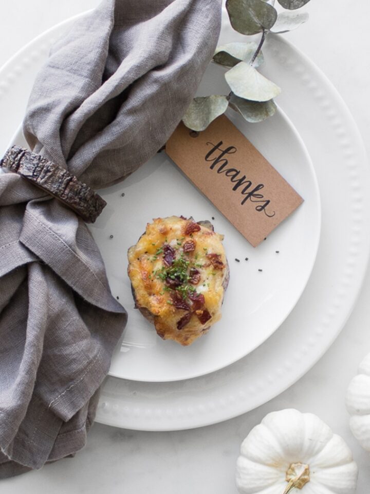 Stuffed Twice Baked Potato on a white plate with a grey napkin