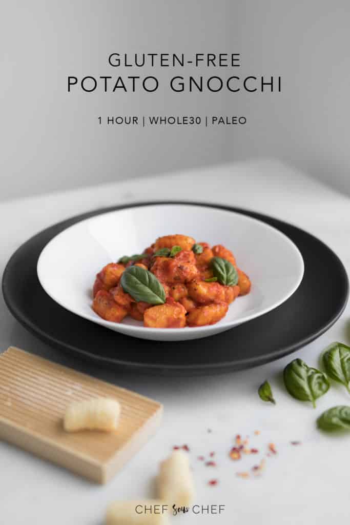 Whole30 Gnocchi in a white bowl placed on black plate with gnocchi board and basil