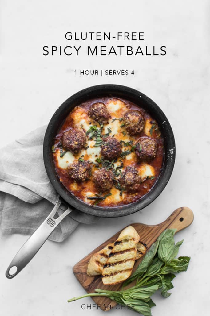 Gluten-Free Spicy Meatballs in a cast iron skillet with bread and basil