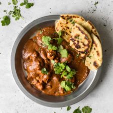 Butter Chicken with Coconut Milk in Silver Bowl with Cilantro and Naan