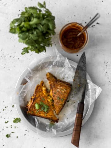 Butter Chicken Grilled Cheese with knife and cilantro