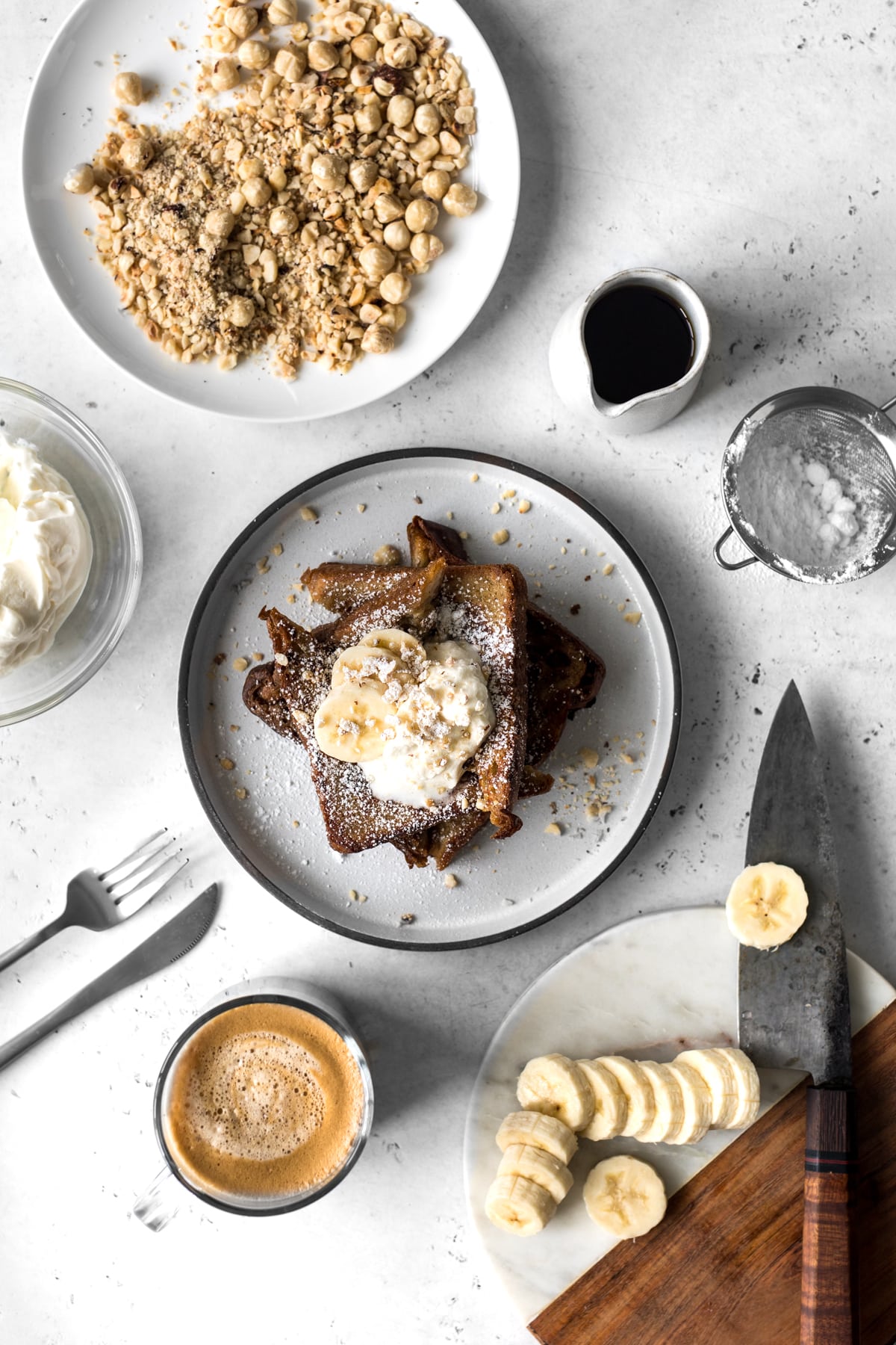 Cinnamon French Toast with whipped cream with sliced bananas, hazelnuts, coffee and maple syrup