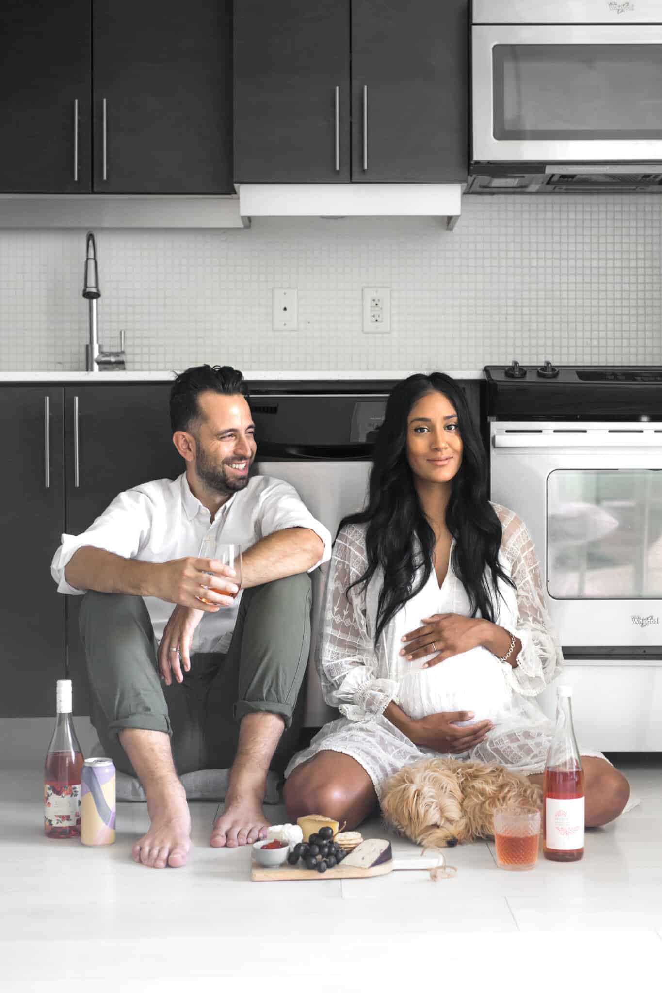 Philip Lago and Mystique Mattai of Chef Sous Chef | Interracial couple sitting on the floor with wine, cider, and cheeseboard.