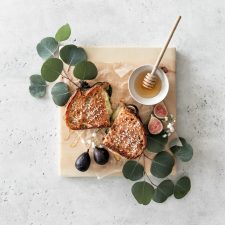Gourmet Grilled Cheese Sandwich with Figs and Honey on a wooden board