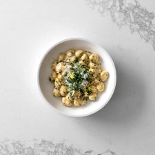 Bowl of gnocchi in cream sauce with basil, parmesan and lemon zest