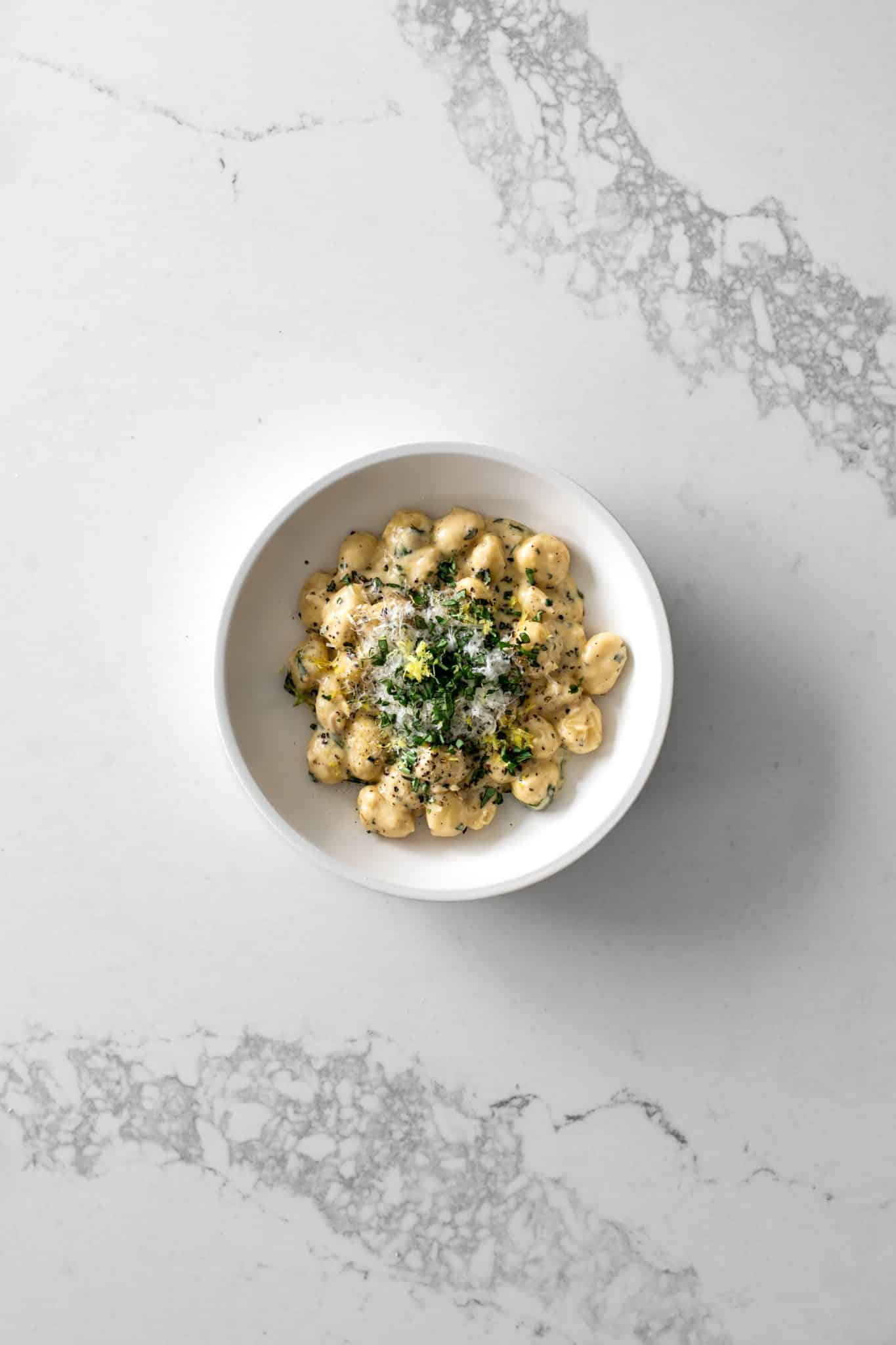 Bowl of one-pot gnocchi with lemon cream sauce with basil, parmesan and lemon zest