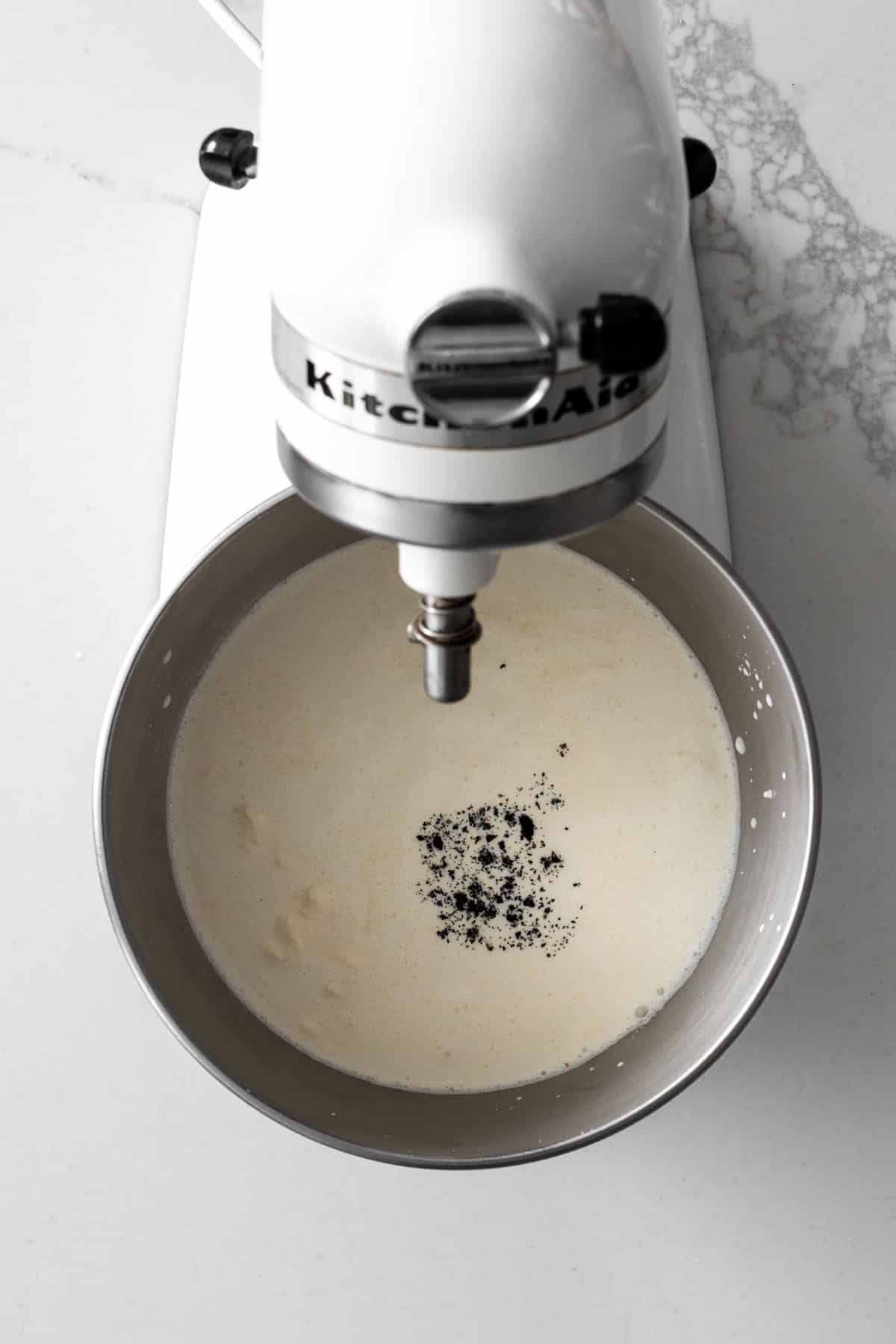 White Kitchen-aid mixer with cream and vanilla bean.