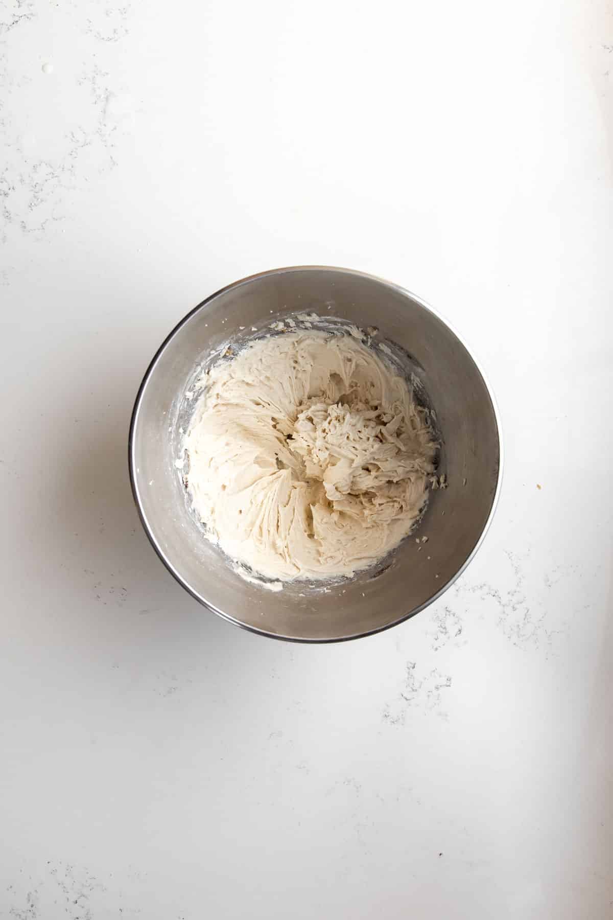 Brown butter frosting in a mixing bowl.