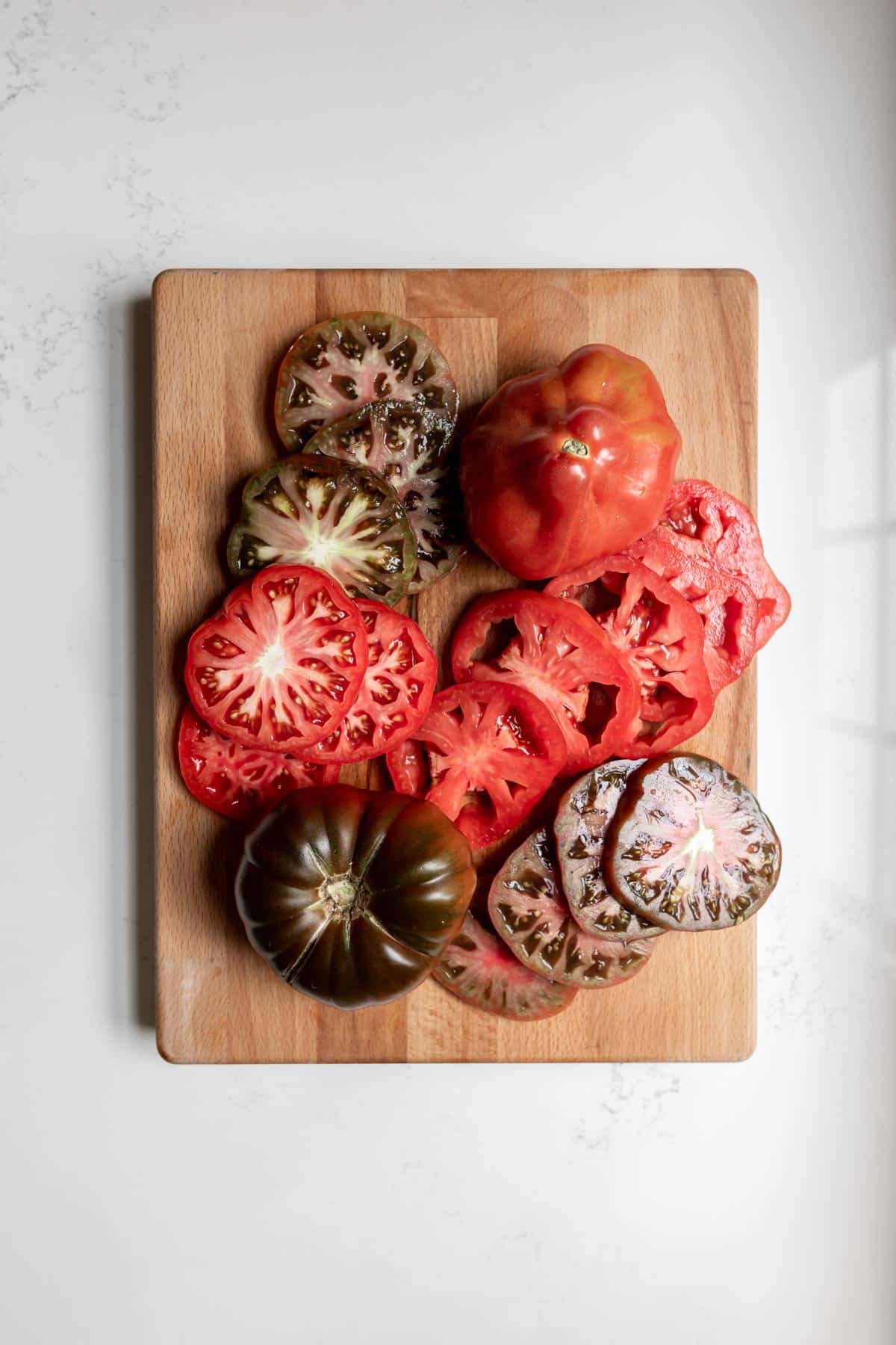 Sliced heirloom tomatoes on a cutting board.