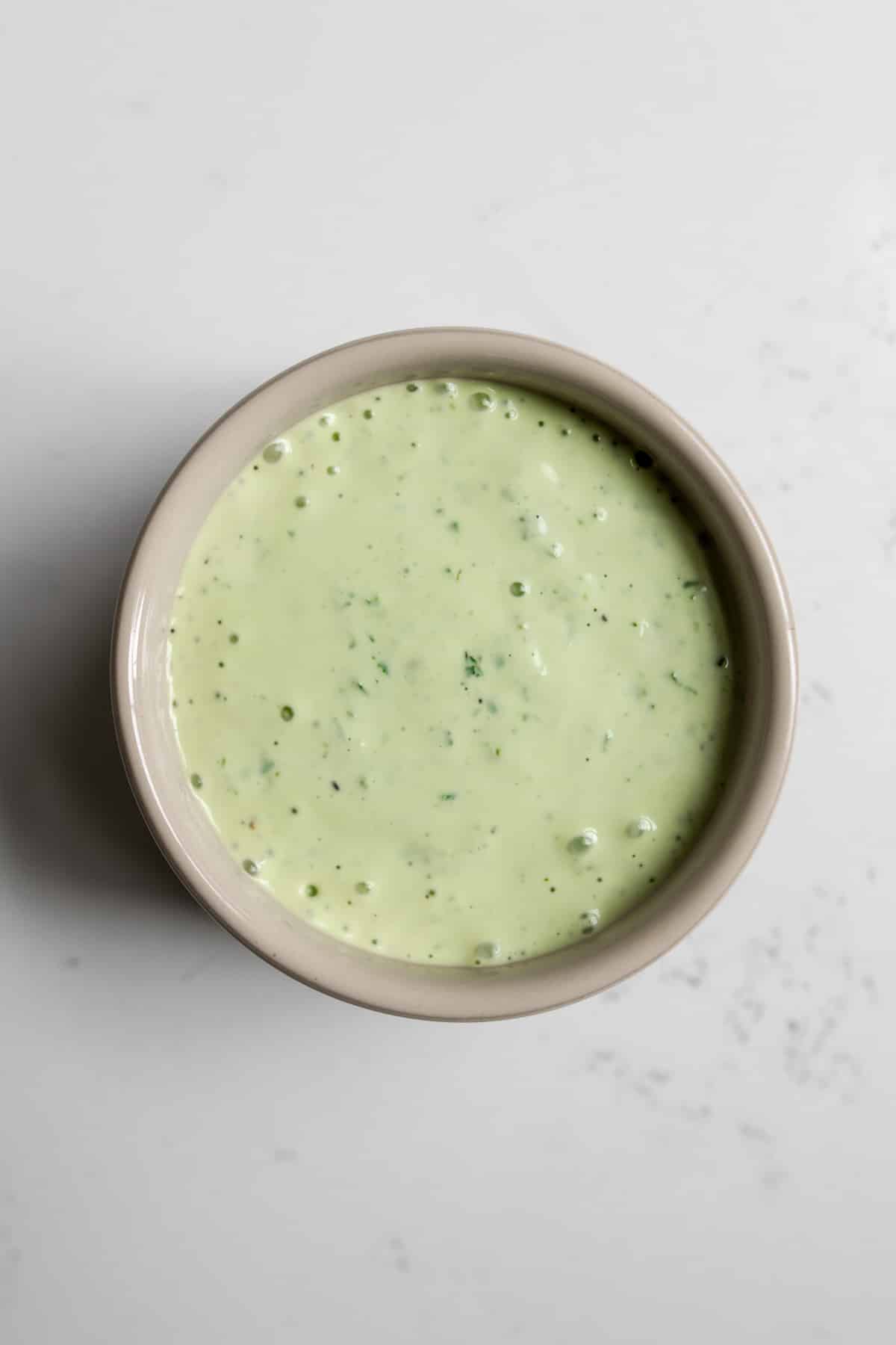 Ramekin of basil mayonnaise sauce.