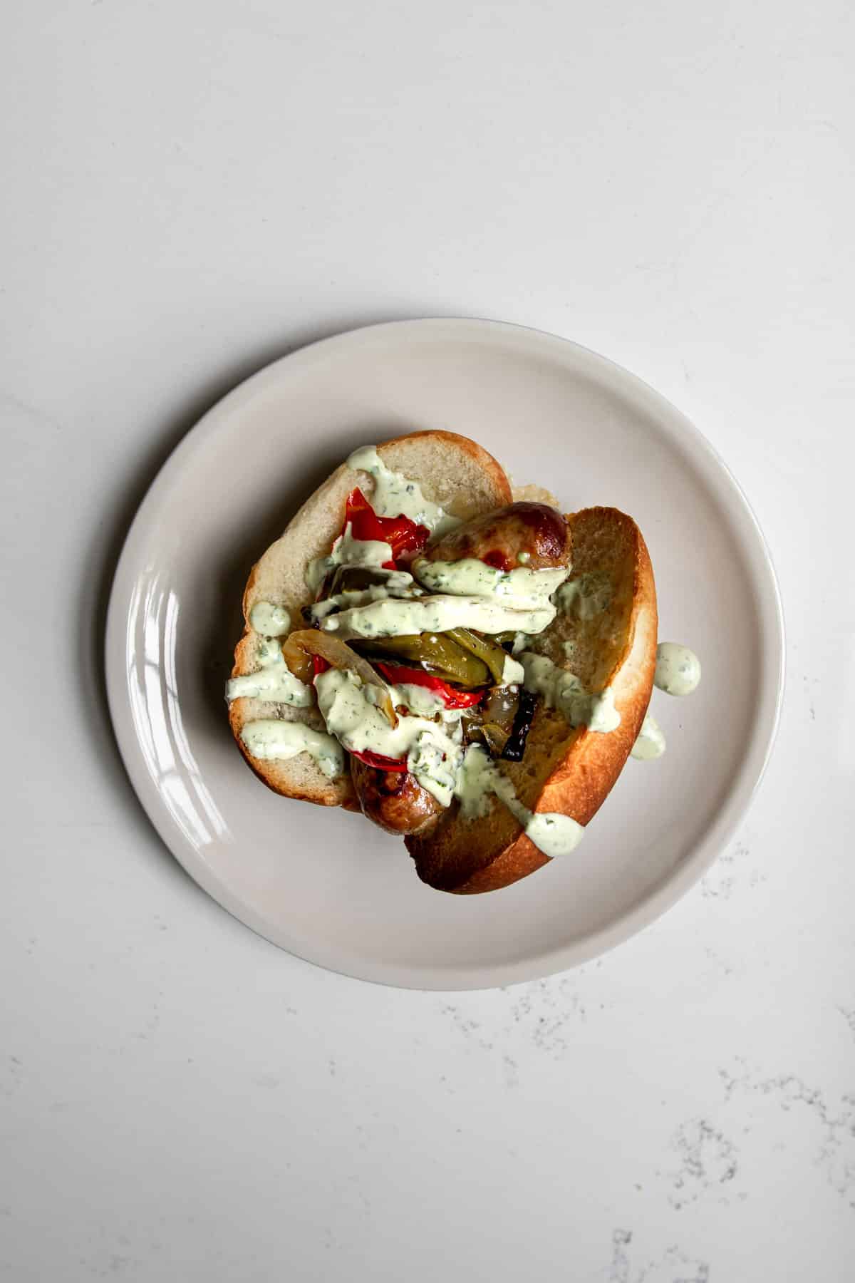 Italian Sausage Sandwich with Onions, Peppers and Basil Aioli Sauce.